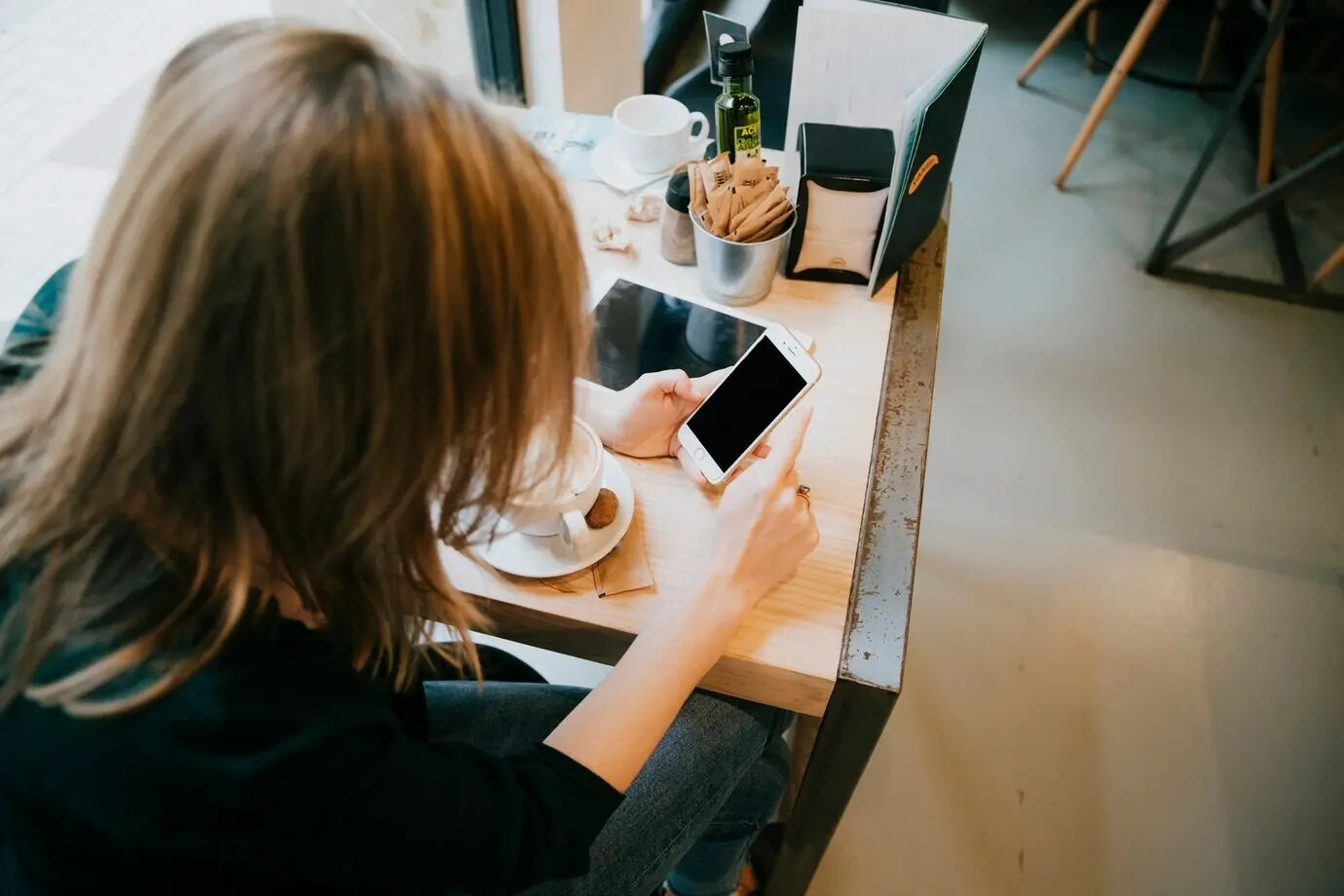 A woman using a smartphone with a black screen