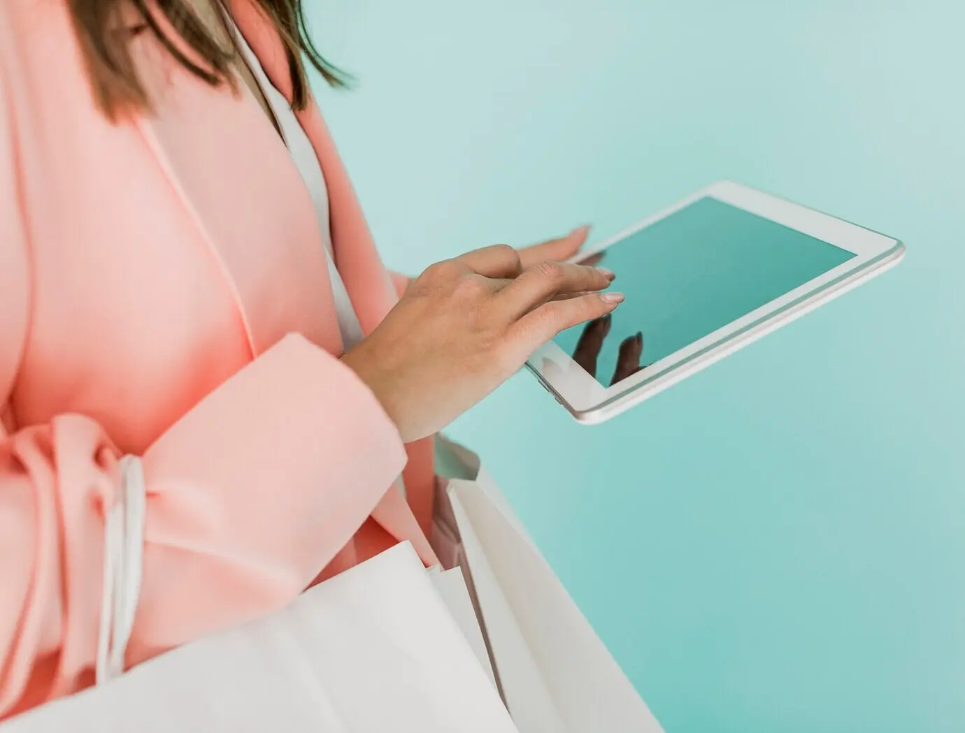 Brown-haired woman with a tablet and shopping bags
